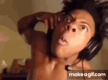 A Shirtless Man Is Wearing Headphones And Making A Face . GIF