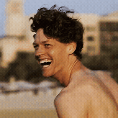 A Shirtless Man Laughs With His Mouth Open GIF