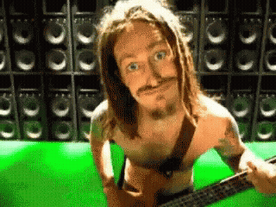 A Shirtless Man Playing A Guitar In Front Of Speakers GIF