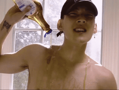A Shirtless Man Pouring Syrup From A Bottle GIF