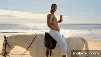 A Shirtless Man Riding A White Horse On A Beach GIF