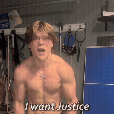 A Shirtless Man Says I Want Justice In Front Of A Blue Table GIF