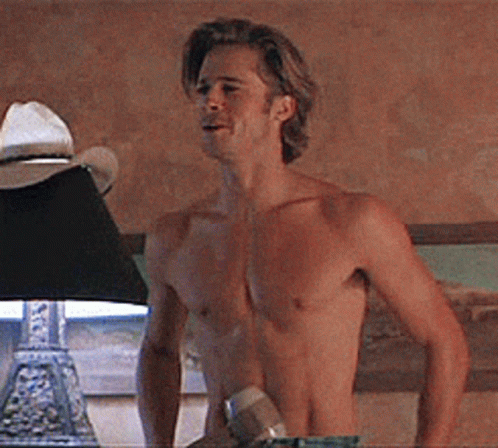 A Shirtless Man Standing Next To A Lamp GIF