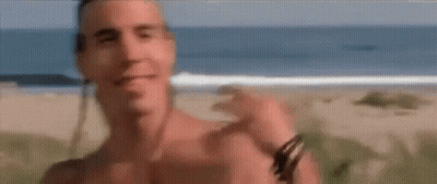 A Shirtless Man Standing On A Beach With The Words That Would Above Him GIF