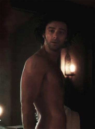 A Shirtless Man Stands In A Dark Room GIF