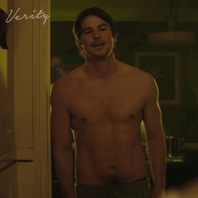 A Shirtless Man Stands In A Doorway With The Word Verity Written On The Wall GIF