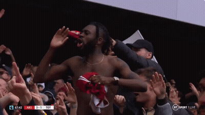 A Shirtless Man Stands In Front Of A Crowd At A Soccer Game GIF