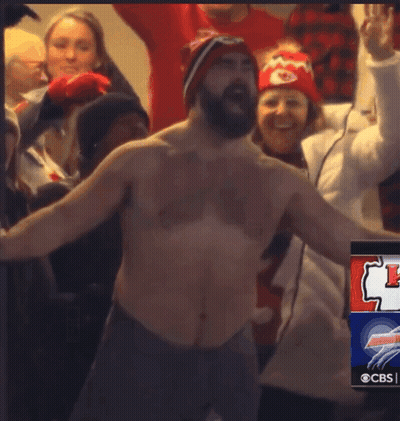 A Shirtless Man Stands In Front Of A Crowd Of People With A Cbs Advertisement In The Corner GIF