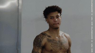 A Shirtless Man Stands In Front Of A Wall That Says Wave Part GIF