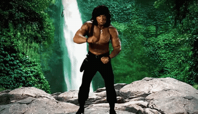 A Shirtless Man Stands In Front Of A Waterfall GIF