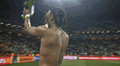 A Shirtless Man Stands On A Soccer Field In Front Of A Donald 'S Sign GIF