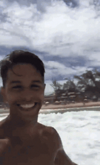 A Shirtless Man Taking A Selfie In The Ocean GIF