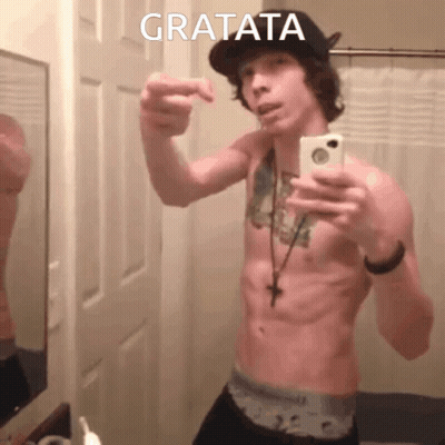 A Shirtless Man Taking A Selfie With Gratata Written On The Bottom Right GIF