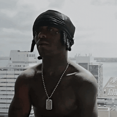 A Shirtless Man Wearing A Black Bandana And A Necklace With A Dog Tag On It GIF
