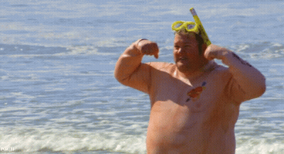 A Shirtless Man Wearing A Snorkel And Goggles Flexes His Muscles On A Beach GIF