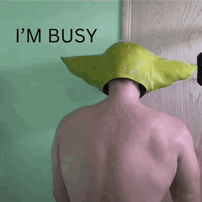 A Shirtless Man Wearing A Yellow Hat With The Words I 'M Busy Behind Him GIF