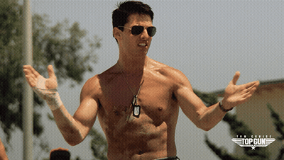 A Shirtless Man Wearing Sunglasses Stands In Front Of A Poster For Top Gun GIF