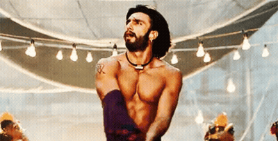 A Shirtless Man With A Beard Is Dancing In A Room With A Lot Of Lights . GIF