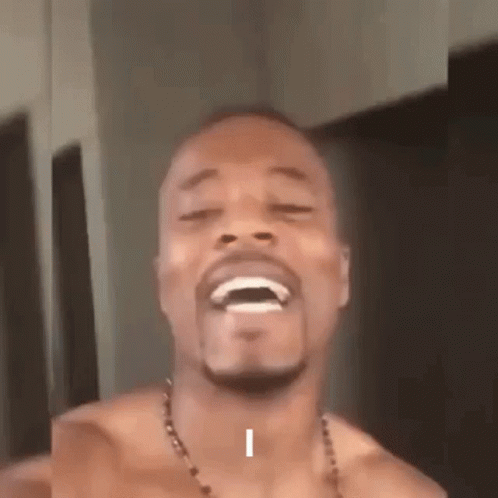 A Shirtless Man With A Beard Is Laughing With His Eyes Closed And His Mouth Open . GIF
