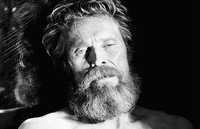 A Shirtless Man With A Beard Is Laying Down With His Eyes Closed GIF