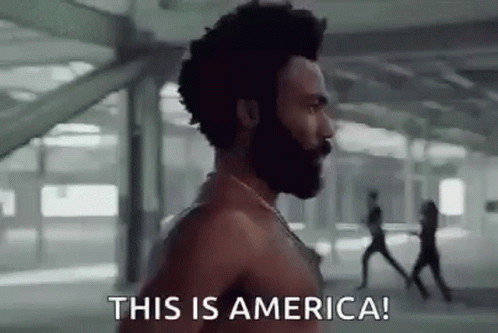 A Shirtless Man With A Beard Is Running In A Building And Saying `` This Is America ! '' GIF