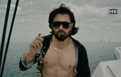 A Shirtless Man With A Beard Is Smoking A Cigarette On A Boat GIF