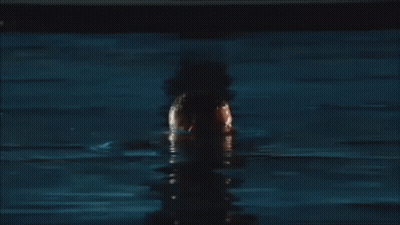 A Shirtless Man With A Beard Is Standing In A Body Of Water . GIF