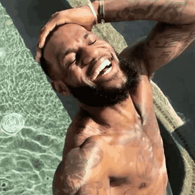 A Shirtless Man With A Beard Is Standing In A Swimming Pool . GIF