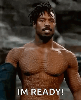 A Shirtless Man With A Beard Is Standing In Front Of A Rock And Says `` Im Ready '' . GIF