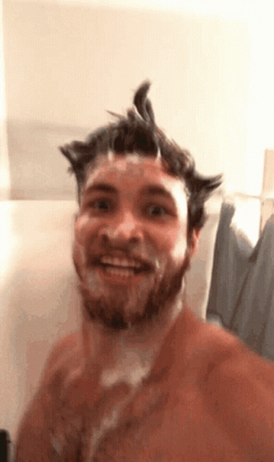 A Shirtless Man With A Beard Is Taking A Shower GIF
