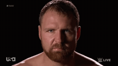 A Shirtless Man With A Beard Looks At The Camera With A Usa Logo In The Background GIF