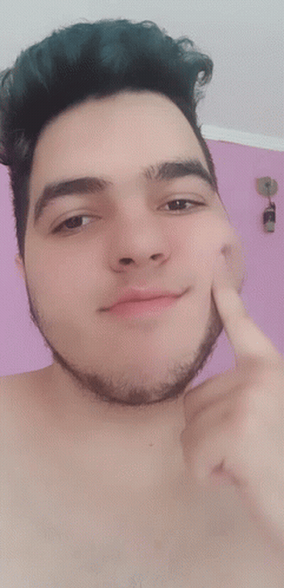A Shirtless Man With A Beard Points To His Face With His Finger GIF