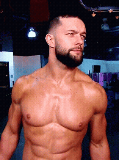 A Shirtless Man With A Beard Stands In A Dark Room GIF