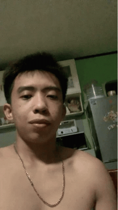 A Shirtless Man With A Chain Around His Neck Is Taking A Selfie GIF