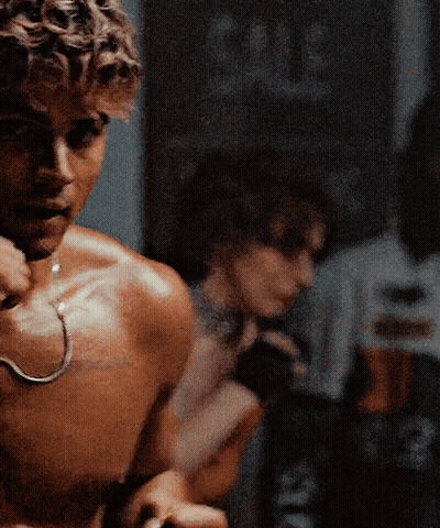 A Shirtless Man With A Hook Around His Neck Is Standing In Front Of A Mirror GIF