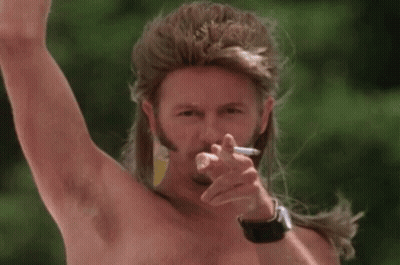 A Shirtless Man With A Mullet Is Smoking A Cigarette . GIF