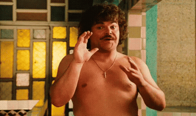 A Shirtless Man With A Mustache And A Necklace Is Standing In Front Of A Mirror . GIF