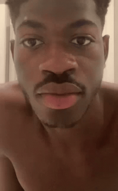 A Shirtless Man With A Mustache Is Making A Funny Face With His Tongue Sticking Out . GIF