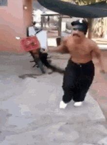 A Shirtless Man With A Mustache Is Running With A Motorcycle In The Background . GIF