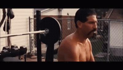 A Shirtless Man With A Mustache Is Squatting On A Bench With A Barbell . GIF