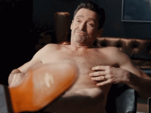 A Shirtless Man With A Ring On His Finger Holds His Chest GIF