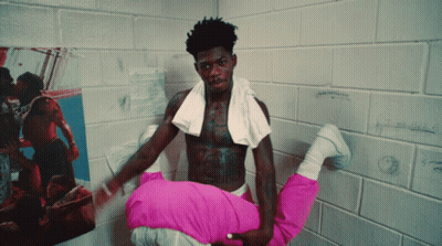 A Shirtless Man With A Towel Around His Neck Holds A Woman In His Arms GIF
