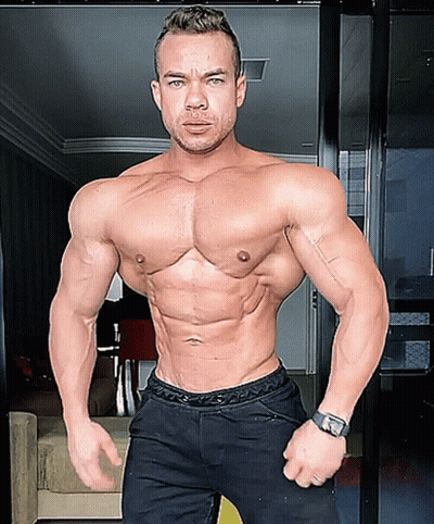 A Shirtless Man With A Watch On His Wrist Is Standing In A Room GIF