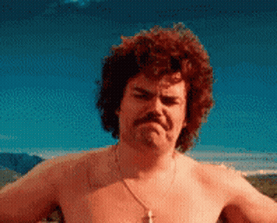 A Shirtless Man With Curly Hair And A Mustache Is Making An Angry Face GIF