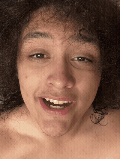 A Shirtless Man With Curly Hair Is Smiling And Making A Funny Face GIF