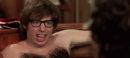 A Shirtless Man With Glasses Is Making A Funny Face While Sitting On A Bench . GIF