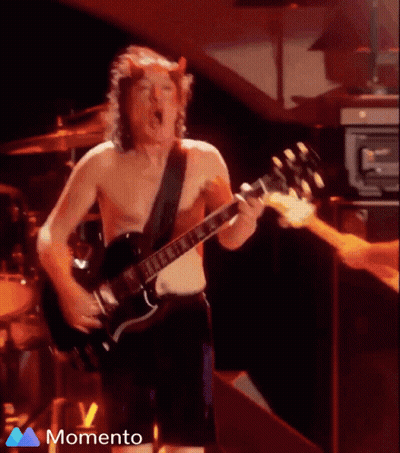 A Shirtless Man With Horns On His Head Is Playing A Guitar On Stage GIF
