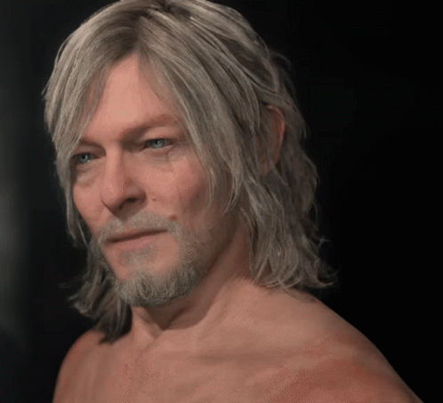 A Shirtless Man With Long Blonde Hair And A Beard Looks At The Camera GIF