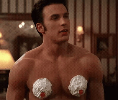 A Shirtless Man With Whipped Cream On His Chest Looks At The Camera GIF