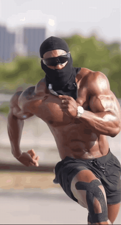 A Shirtless Muscular Man Wearing Sunglasses And A Black Mask Is Running GIF